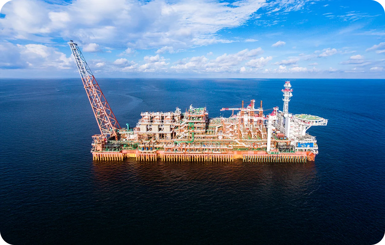 Aerial view of the Jangkrik offshore production unit: a multi-level orange rectangular structure with a large truss.
